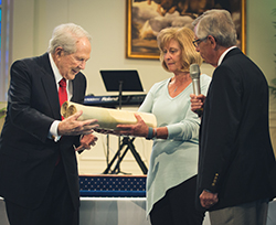 The Larson family presents the Torah to Dr. M.G. "Pat" Robertson. Photo courtesy of Elisa Sosa.