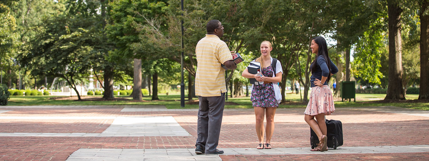 A group chats at the library plaza of Regent University, Virginia Beach.