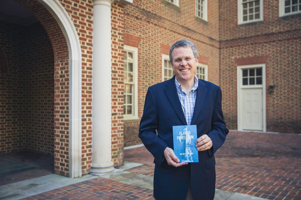 Regent University's law school professor Jeffrey Brauch holds his recent book 'Flawed Perfection: What It Means To Be Human & Why It Matters For Culture, Politics, And Law.'