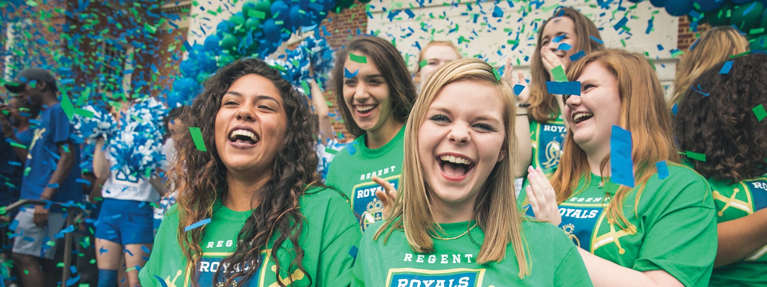 Students cheer during a pep rally at Regent, a university where student life blends academics and fun.