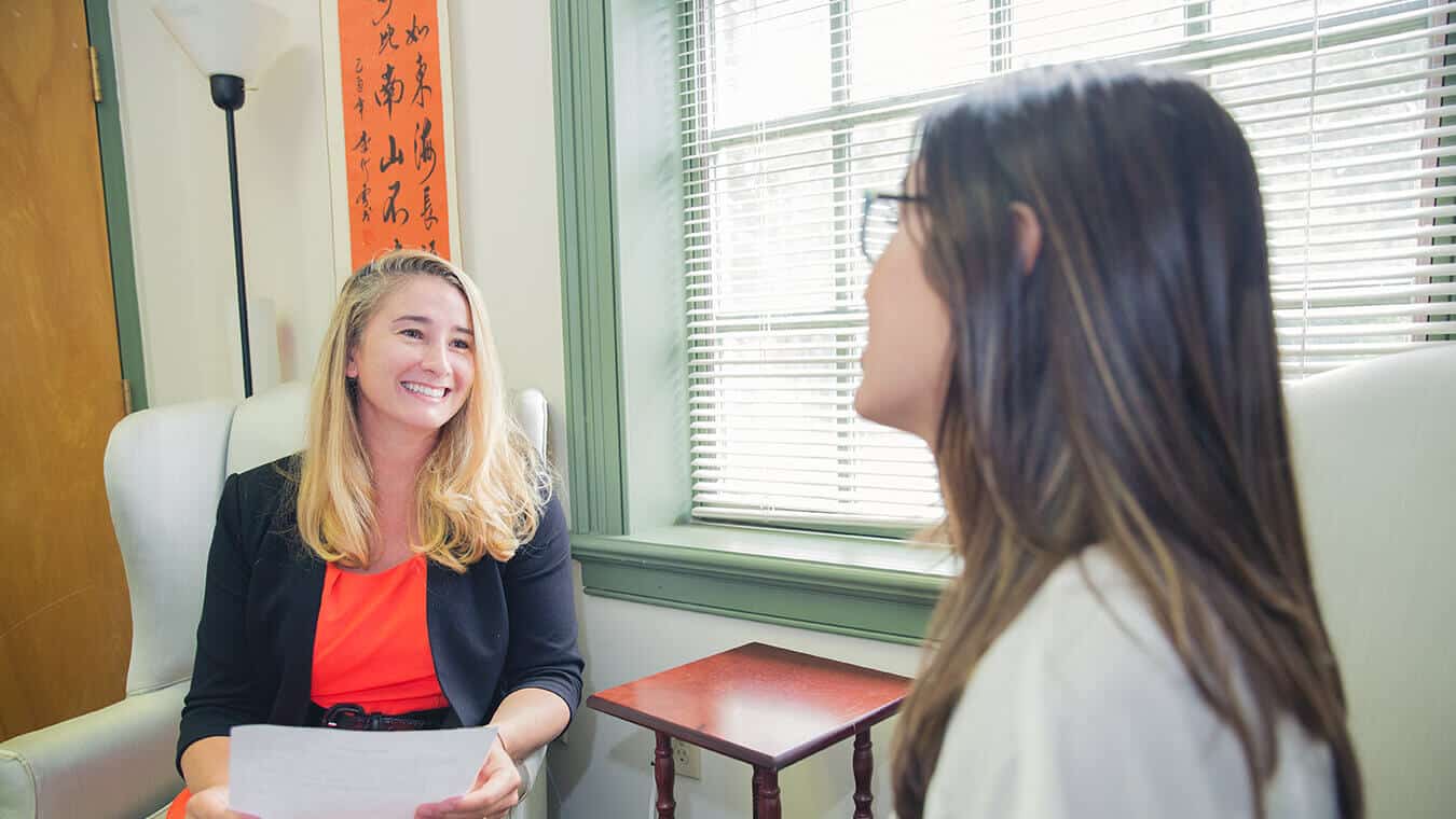 Two graduates interact: Explore Regent's online MA in Human Services - Human Services Counseling program.