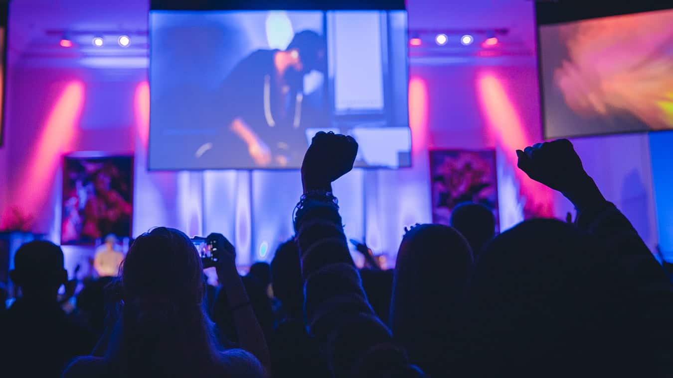 Hands raised during an event at the chapel: Pursue a Master of Arts in Christian Ministry – Worship and Media degree at Regent University.