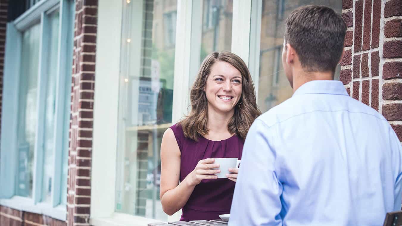 A lady smiles during a conversation: Explore Regent's online master's in psychology – leadership coaching program.