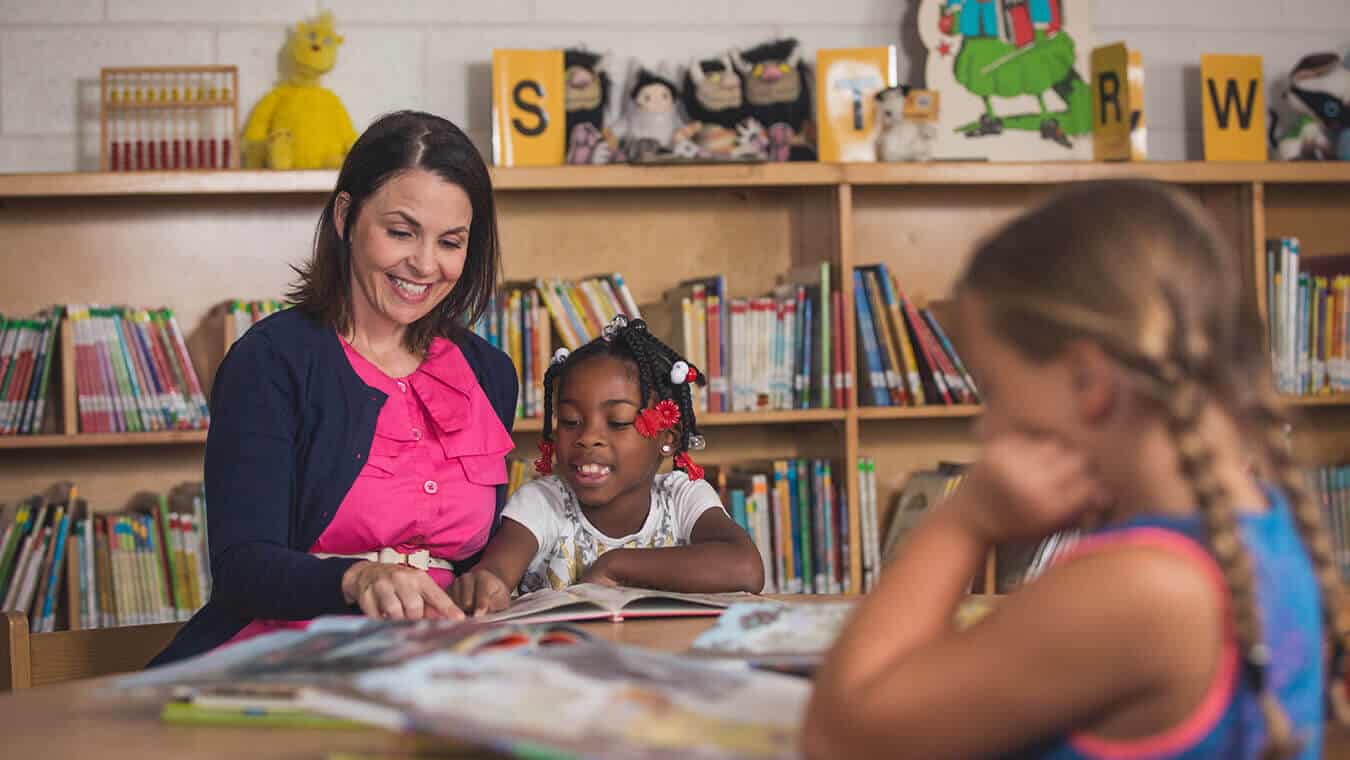 An alumna with students: Pursue a Master of Education degree in Higher Education at Regent University.