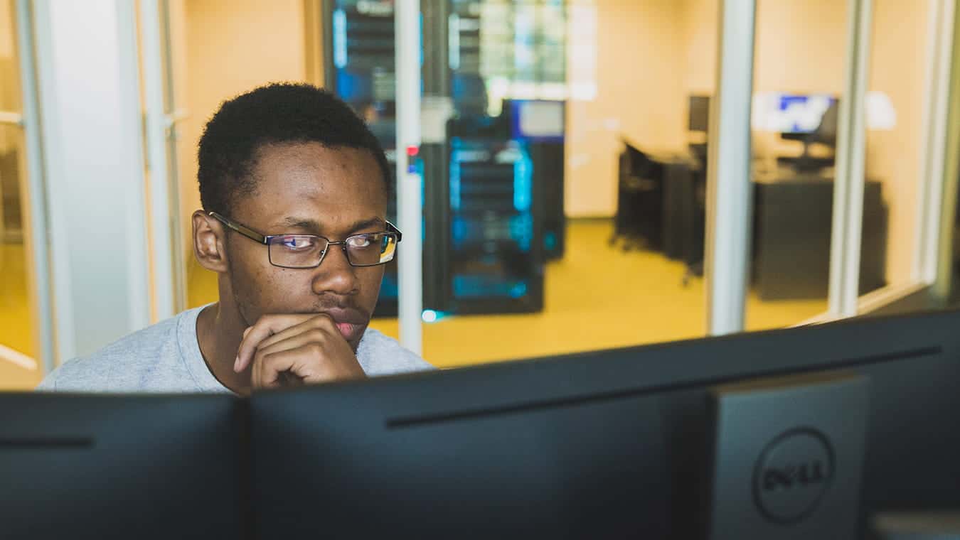 A student looks at his computer screen: Pursue your B.S. in Cyber and Digital Forensics degree online at Regent University, Virginia Beach.