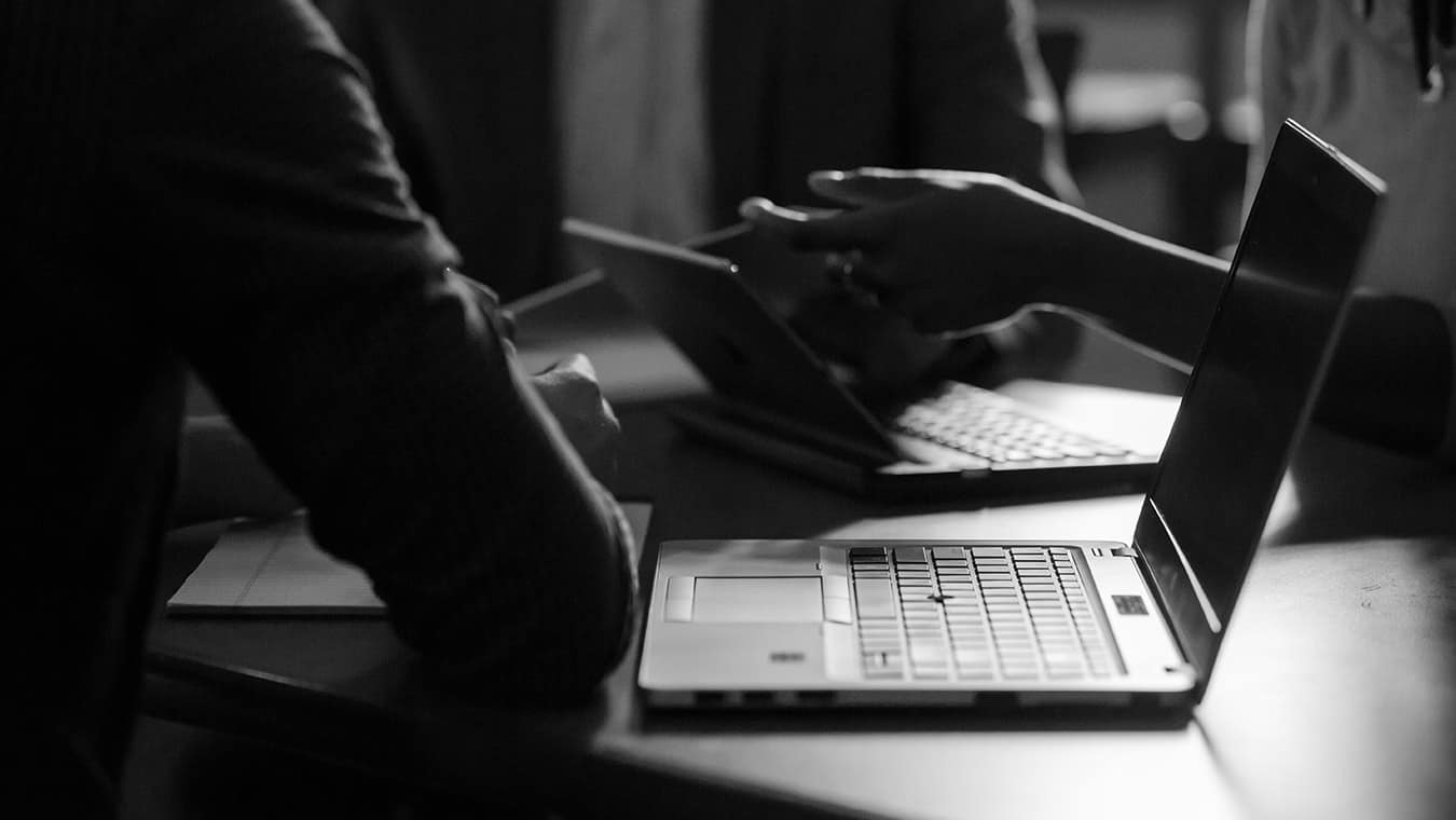 Open laptops during a discussion: Regent University, Virginia Beach, offers a graphic design minor online.