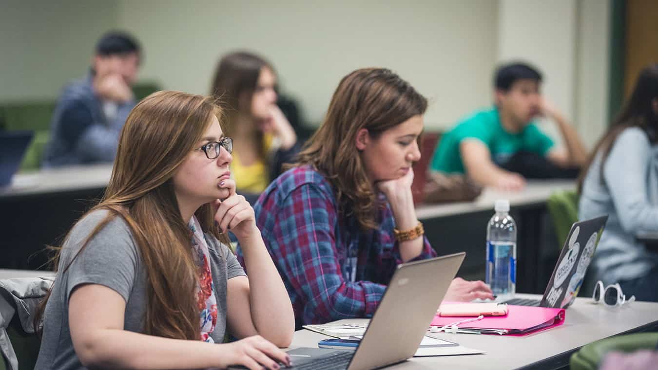 Students in a classroom: Pursue the Associate of Science in Psychology degree at Regent University.