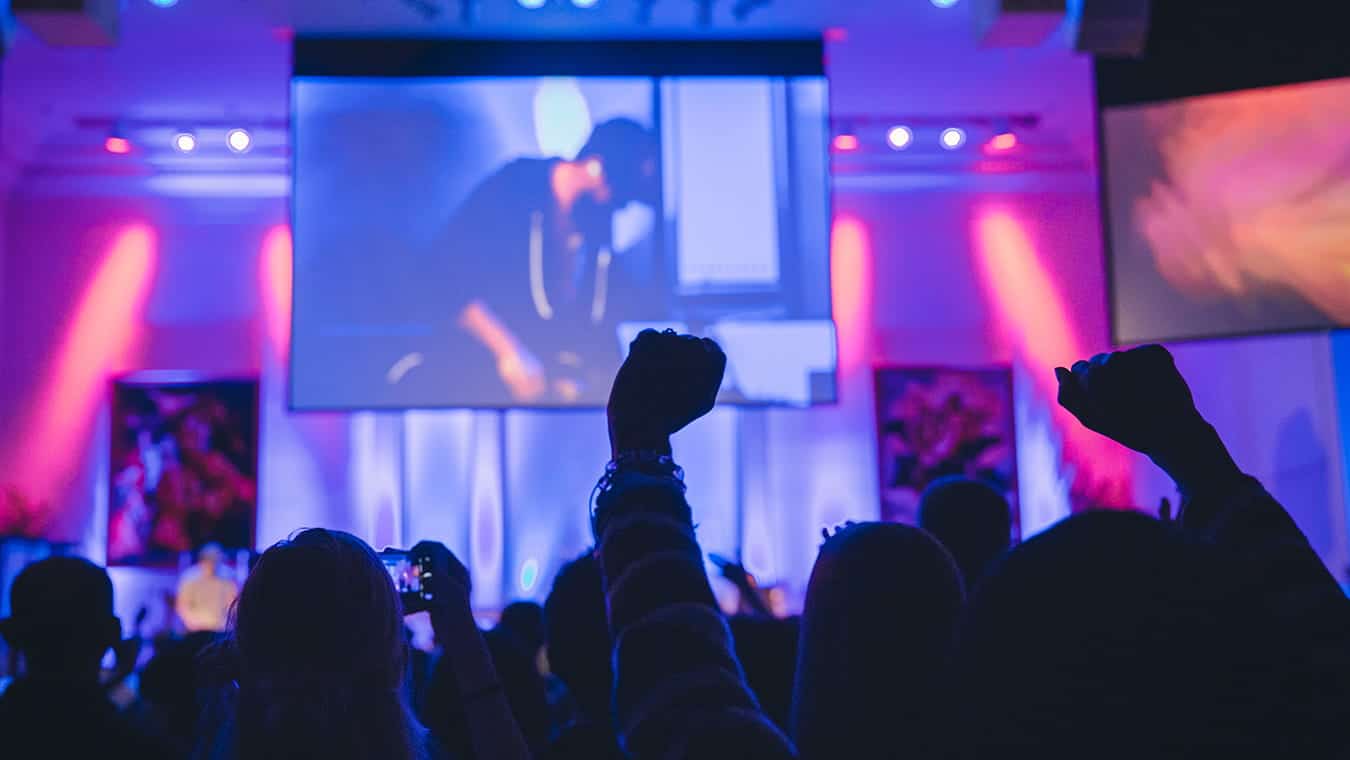 Hands raised during an event at the chapel: Explore the Bachelor of Science in Professional Studies - Christian Ministry degree program offered by Regent University