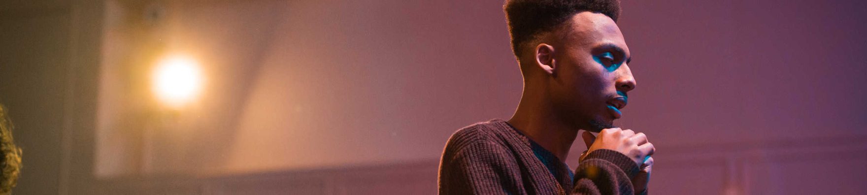 A closeup of a student praying in the chapel at Regent University in Virginia Beach, VA.