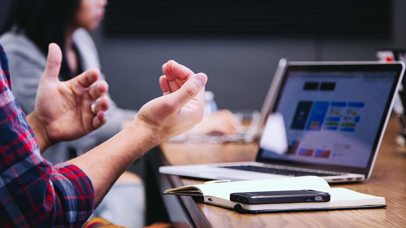 Hands during a meeting: Pursue a business technology management program at Regent University.