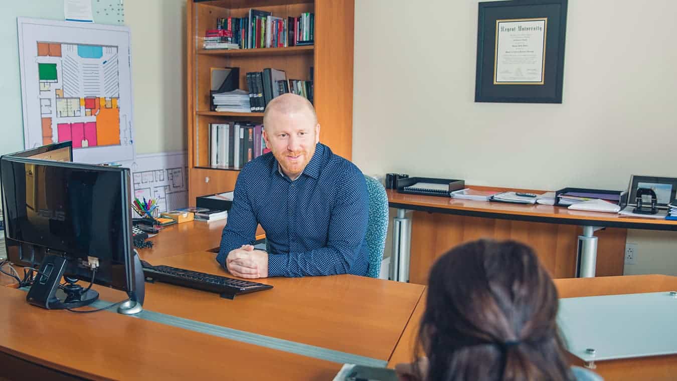 A graduate in his office: Pursue an Organizational Development Consulting program at Regent University.