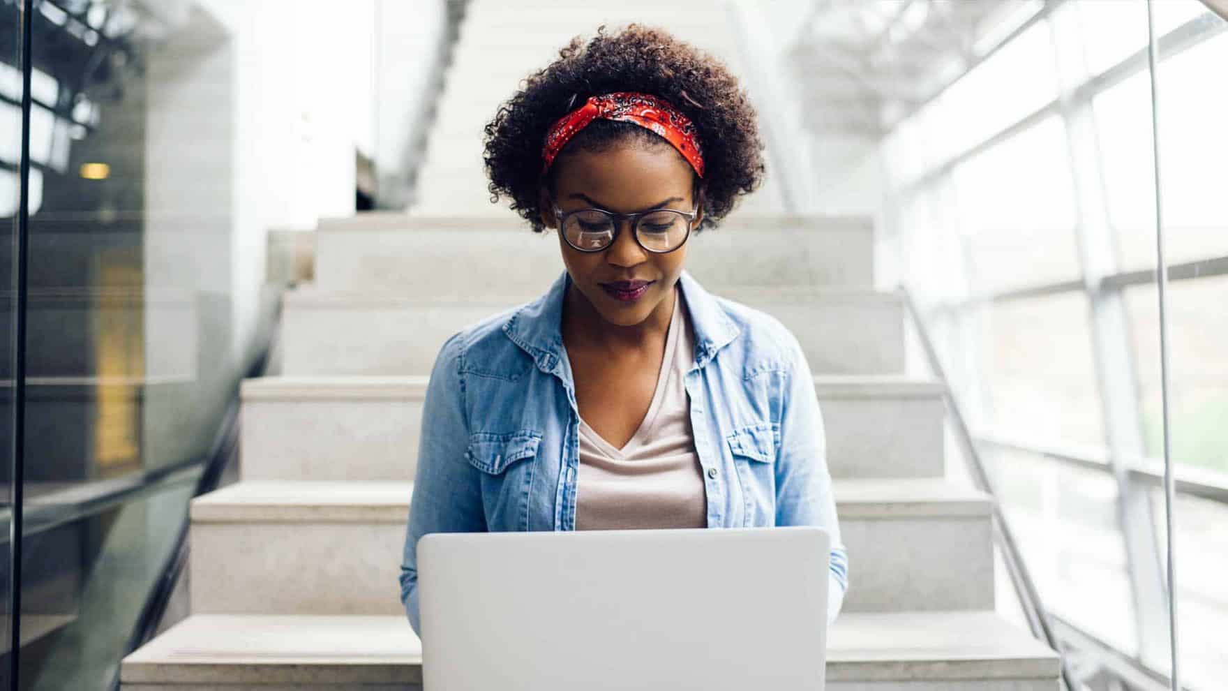 A girl working on her laptop: Access Regent University's net price calculator for college costs.