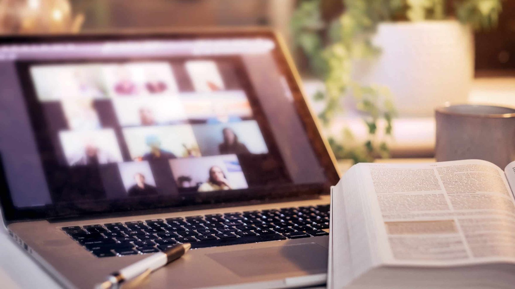 An online ministry group in a video chat on a laptop with a Bible belonging to a student in the Master of Divinity in Theology & Ministry program at Regent University