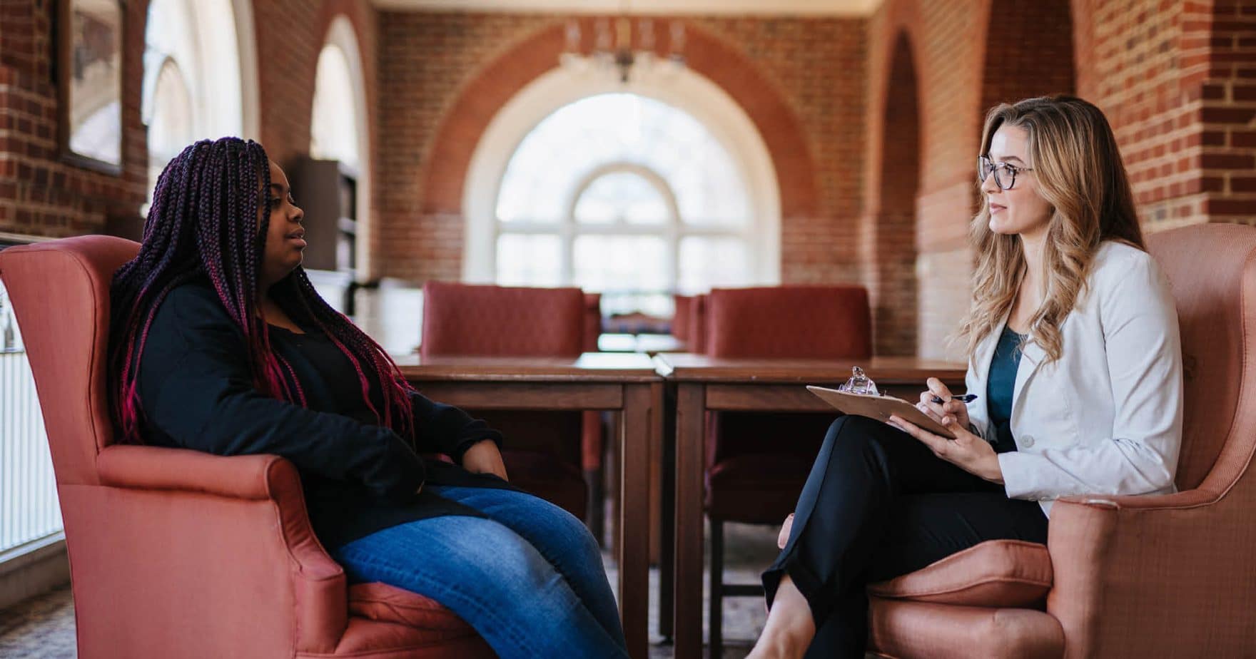 Two Regent University students in the Bachelor's of Psychology program practicing in the university library study balcony.