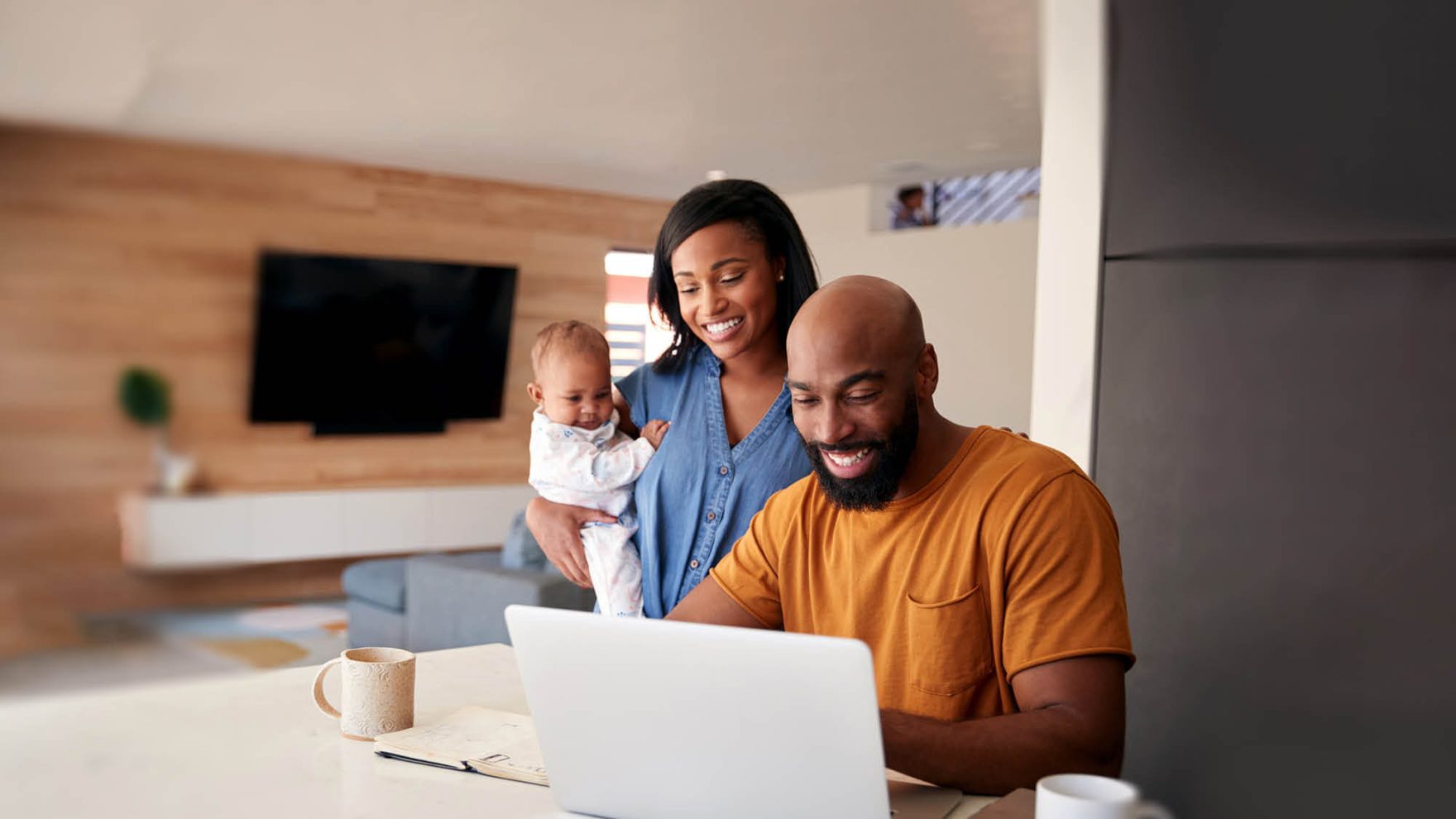 A family smiles while looking at a laptop: Access academic advising for online students.