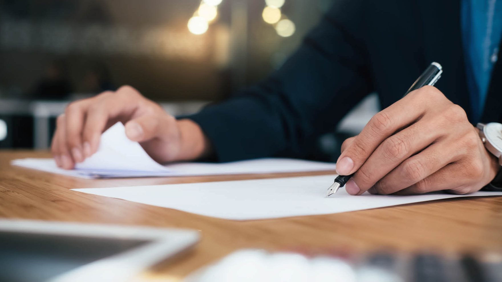 A person writing on a sheet of paper: Explore the master's in national security studies at Regent University.