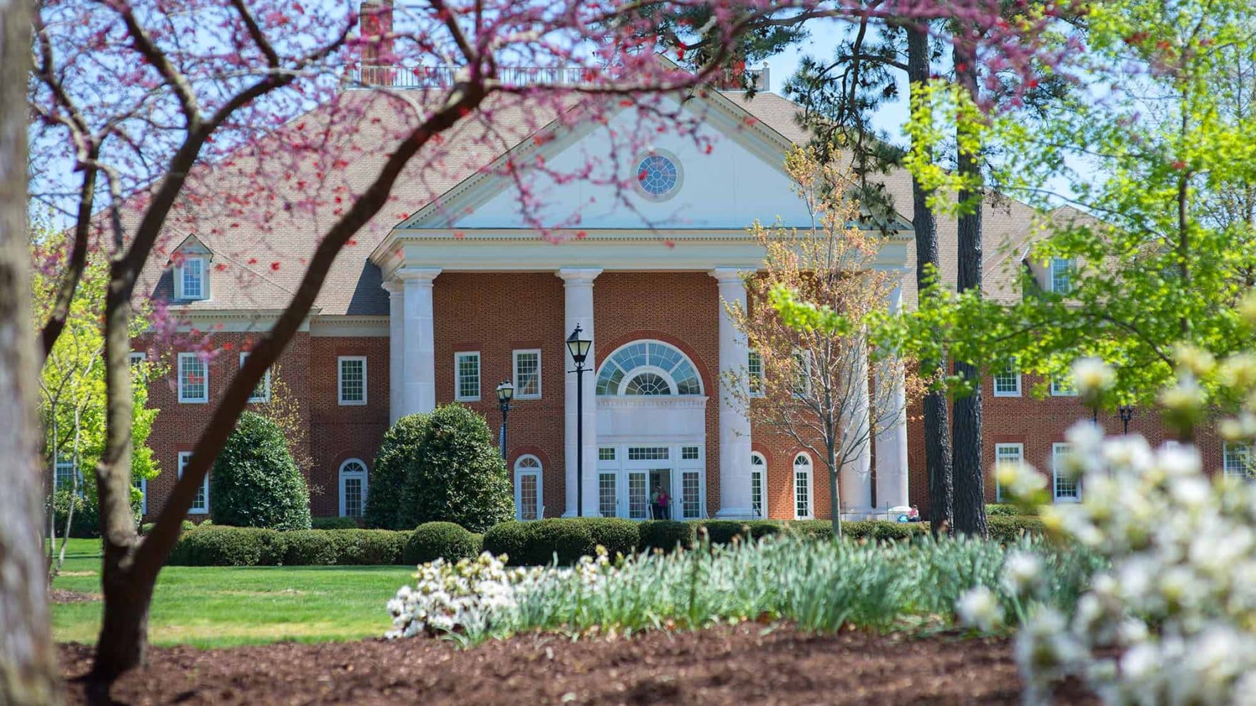 The Communications and Theater building on Regent University's Virginia Beach campus with spring blooms in the foreground