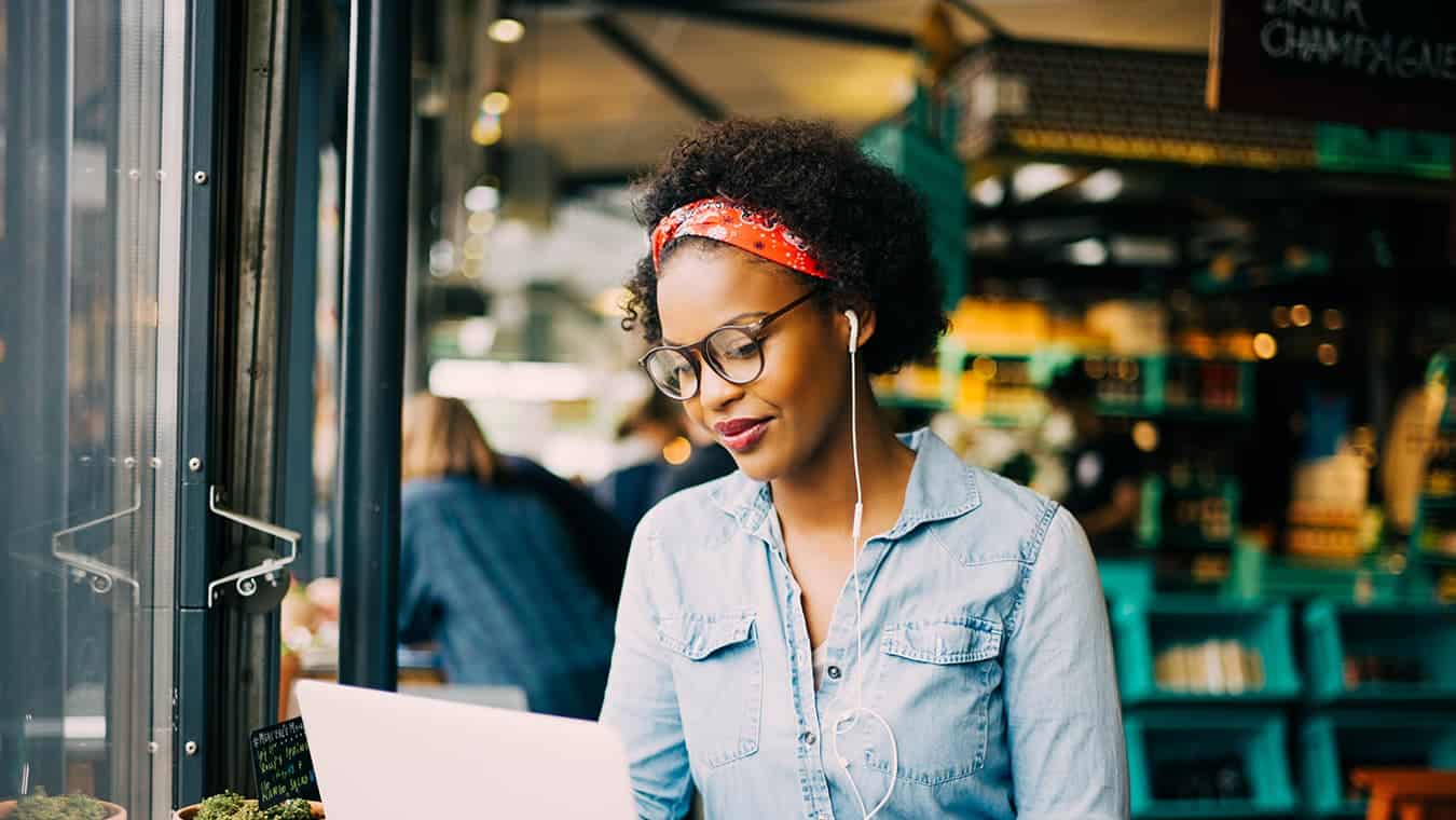 A lady looking at her laptop: Pursue Regent’s B.S. in Marketing degree online or in Virginia Beach, VA 23464.