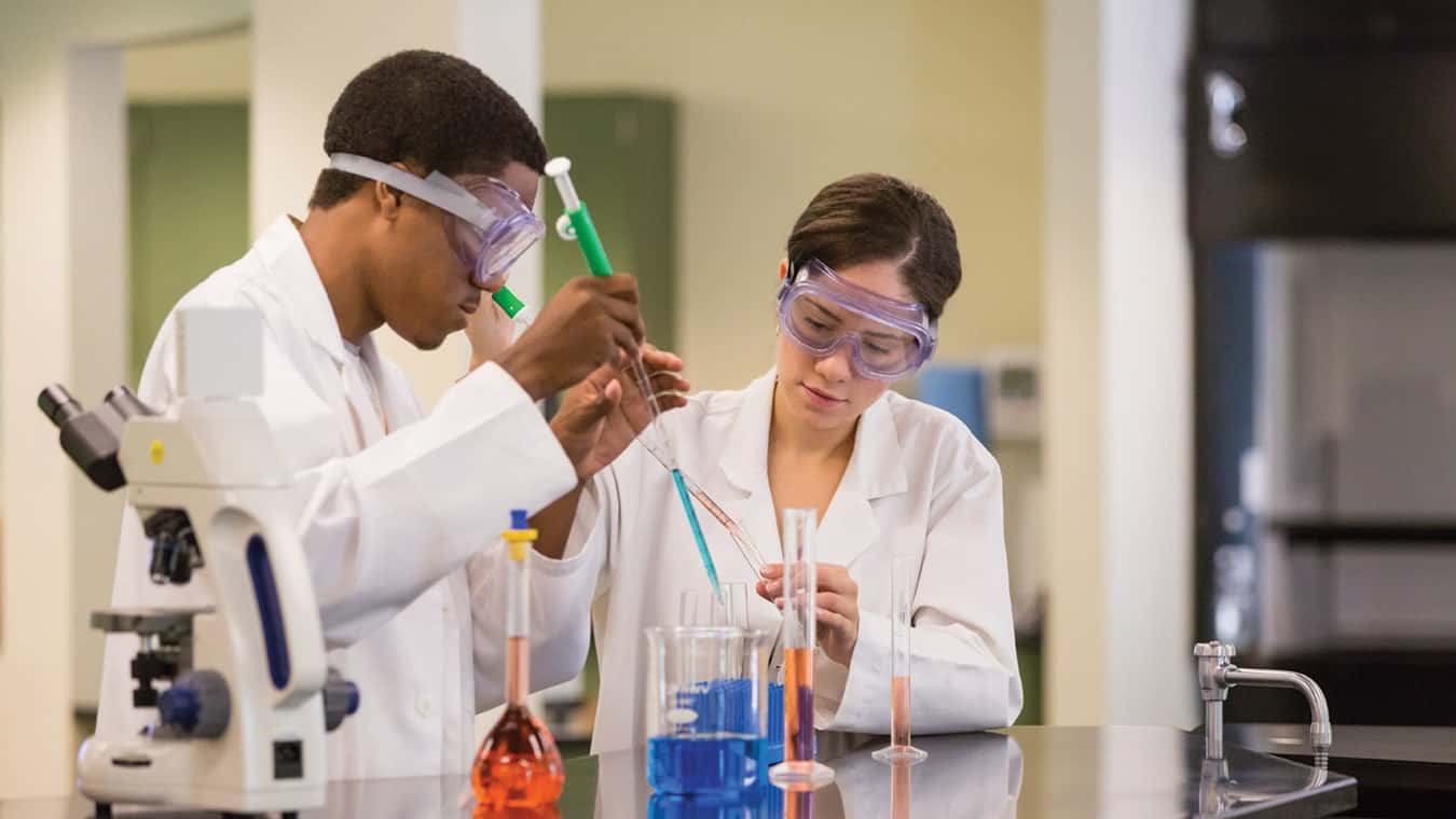 Regent University students at a lab working with test tubes in an undergraduate program on the Virginia Beach campus.