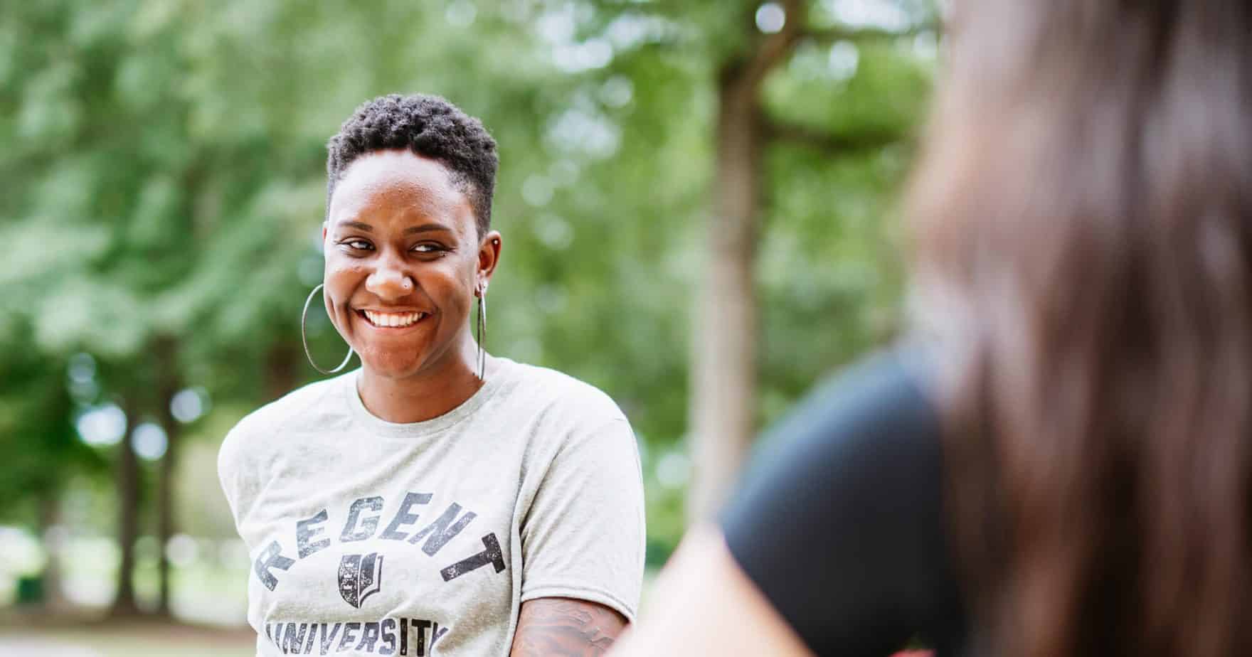 Two friends sit and chat. Learn more about self care for college students at Regent University.