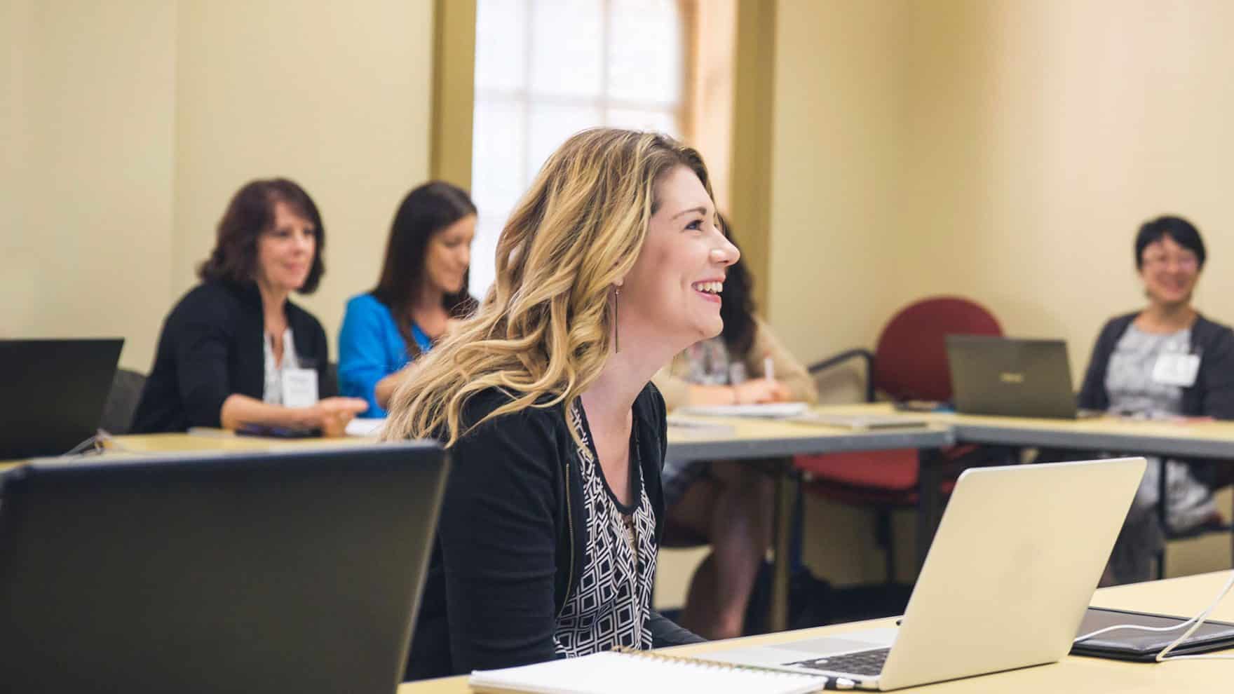 A student smiles during class: Learn about Regent perks for alumni.