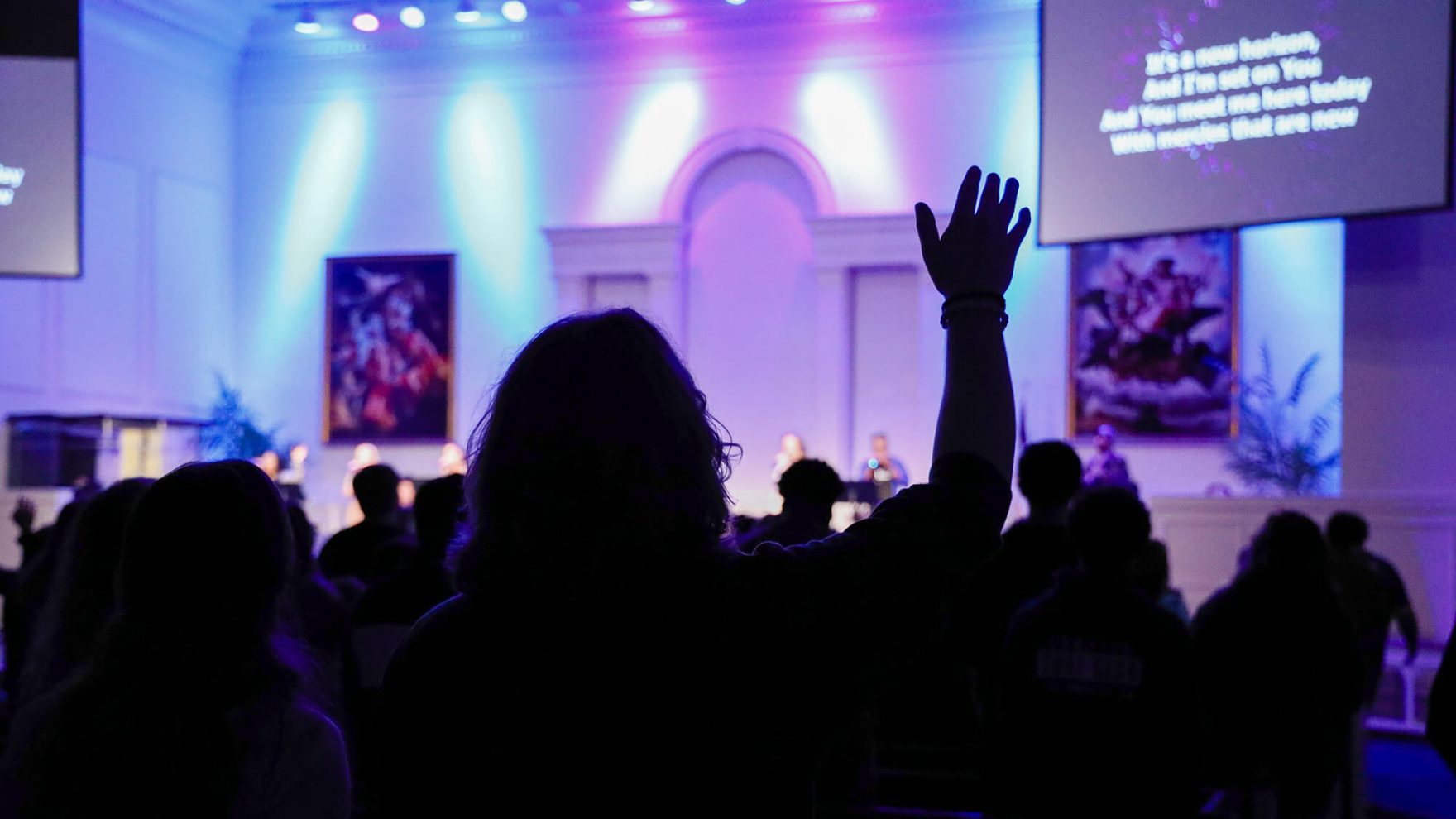 A worship service with hands raised at Regent University in Shaw Chapel.