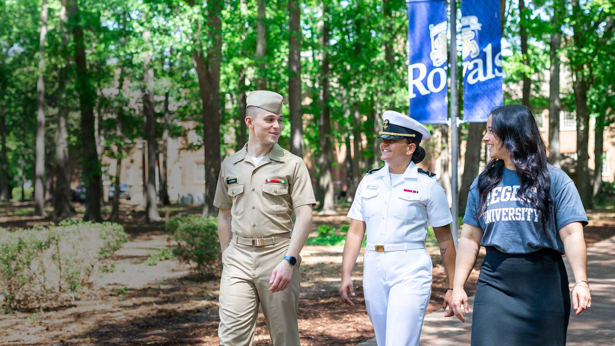 Three Regent University freshmen walking outside, two of which are dressed in military uniforms, where Regent offers many flexible options for military students.