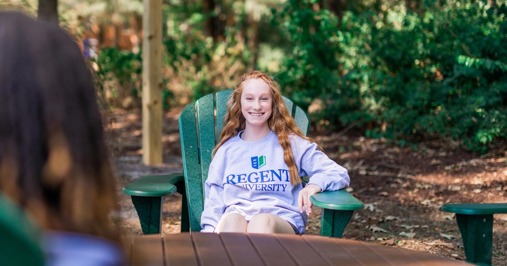 Student sitting outside with at Regent University.